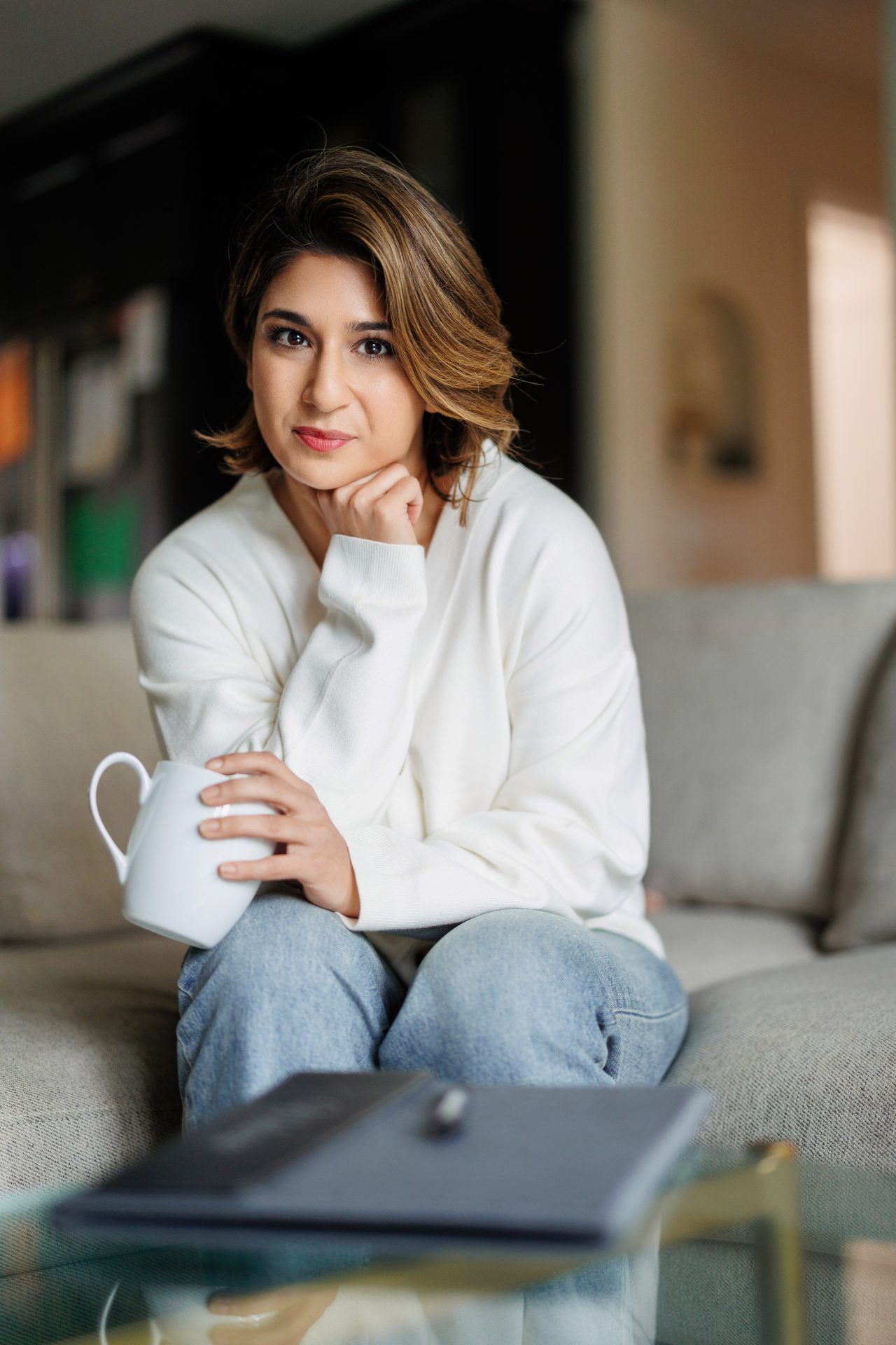 Anastasia Sfiroudis sits on a sofa with her coffee cup in hand and notepad within reach. She is ready for her next client. Her therapy sessions are exactly like this: one-on-one.